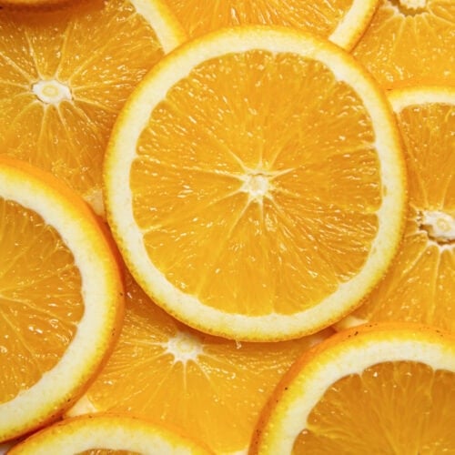 Close-up of a sliced orange, a source of essential oils, revealing its juicy segments and vibrant citrus hues.