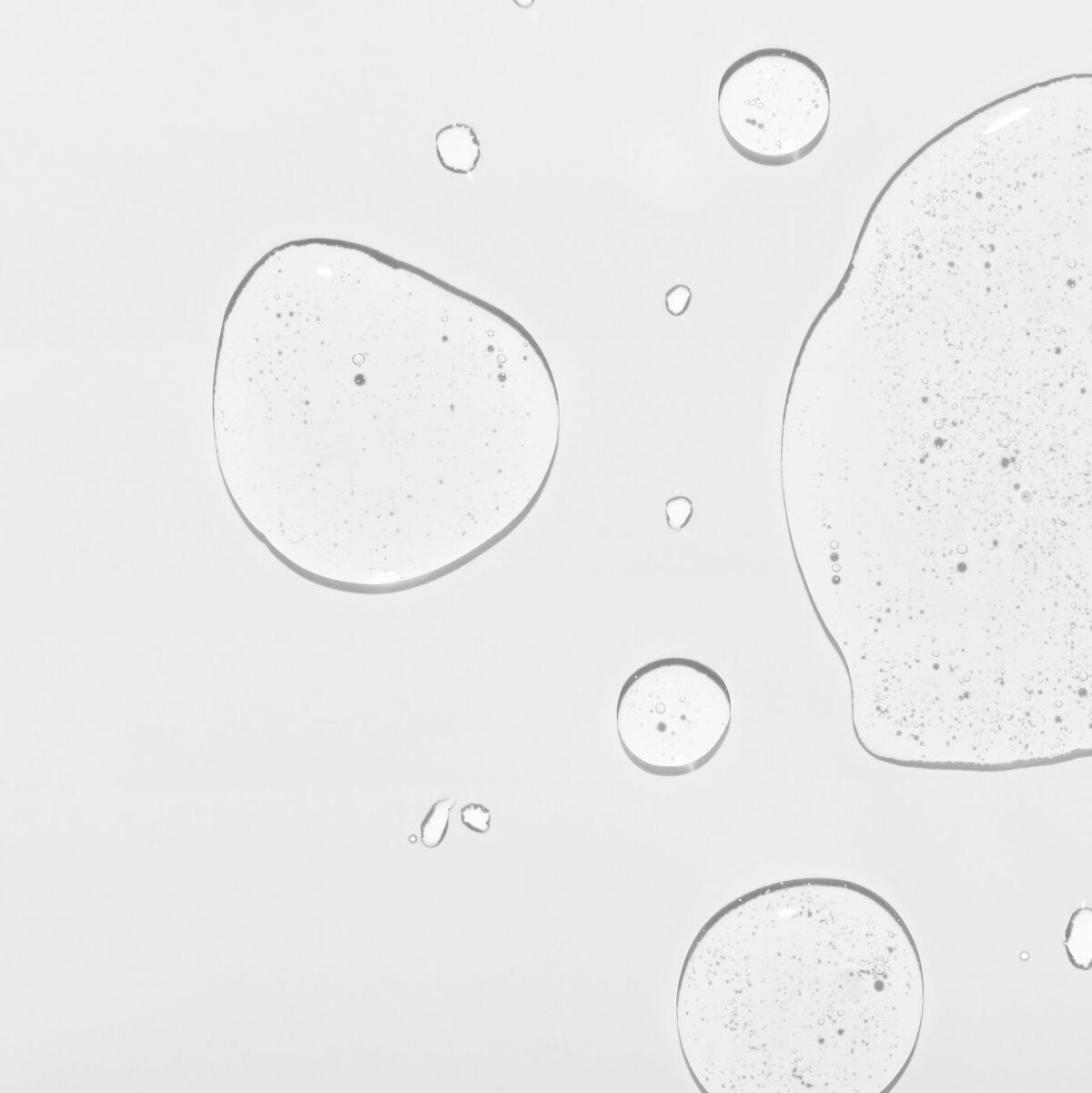 Cosmetic product clear drops and space for design on white surface close upper view. Skincare and dermatological procedures